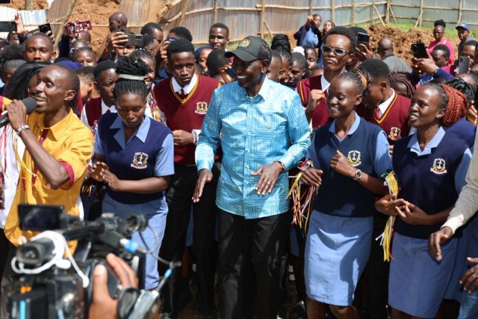 Ruto with KMTC students, now eligible for HELB funding